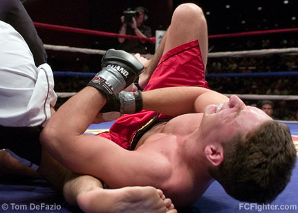Ring of Combat 12: Bill Worfolk writhes in pain after being caught in an armbar by Joe Scarola - Photo by Tom DeFazio